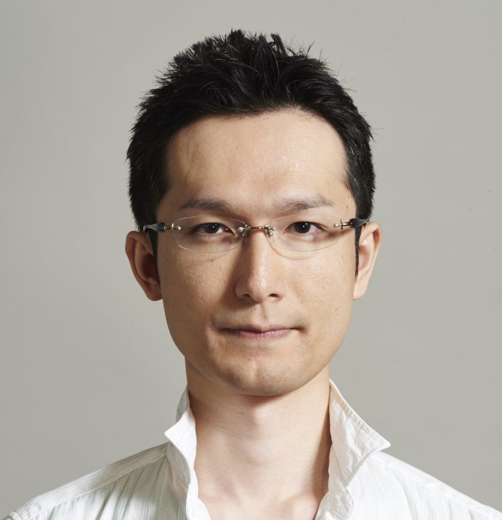杉本幸太郎講師のポートレート。白いシャツを着て眼鏡をかけた男性が微笑んでいる。