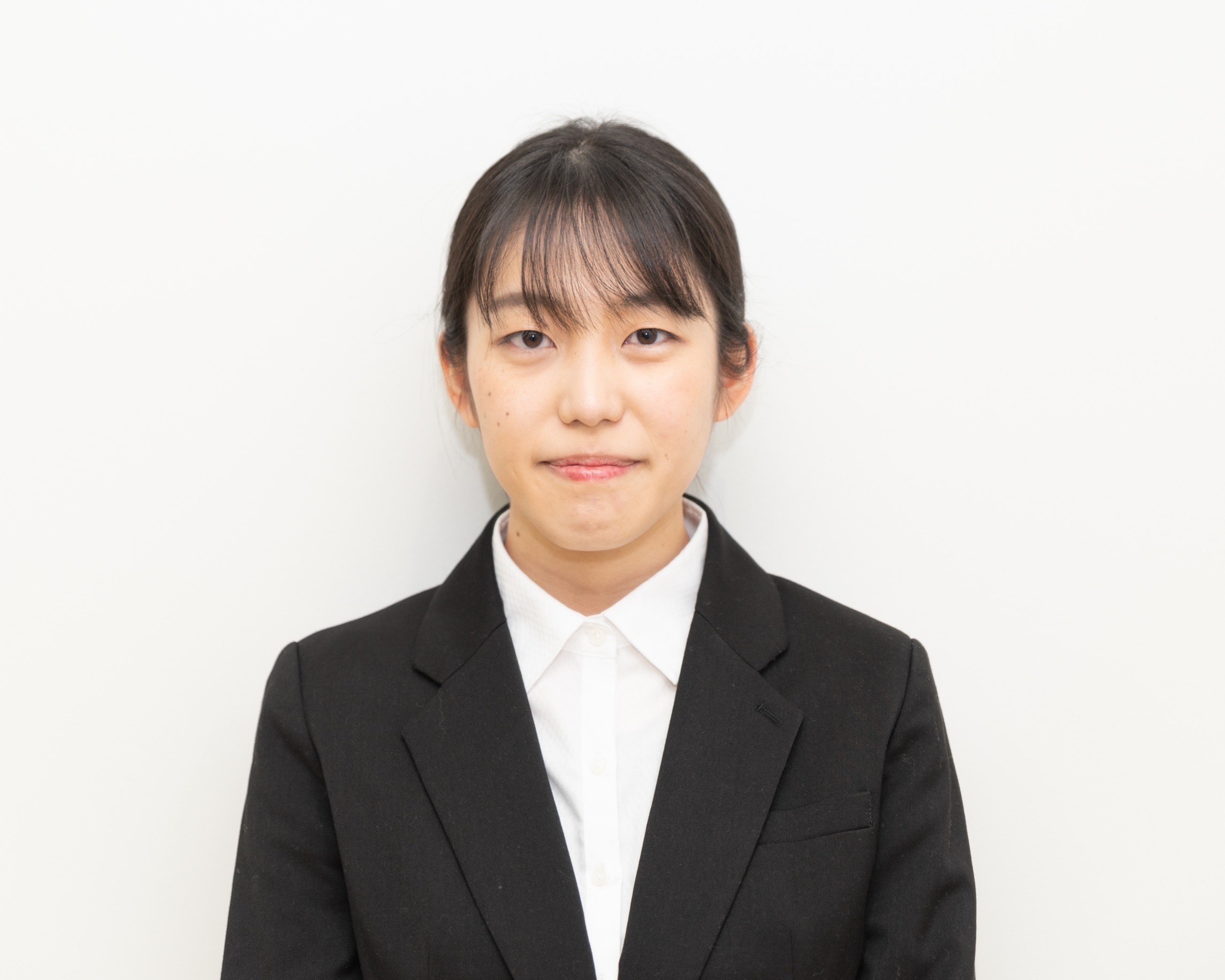 福島県立医科大学の学生がスーツを着て微笑んでいるポートレート。背景は白。