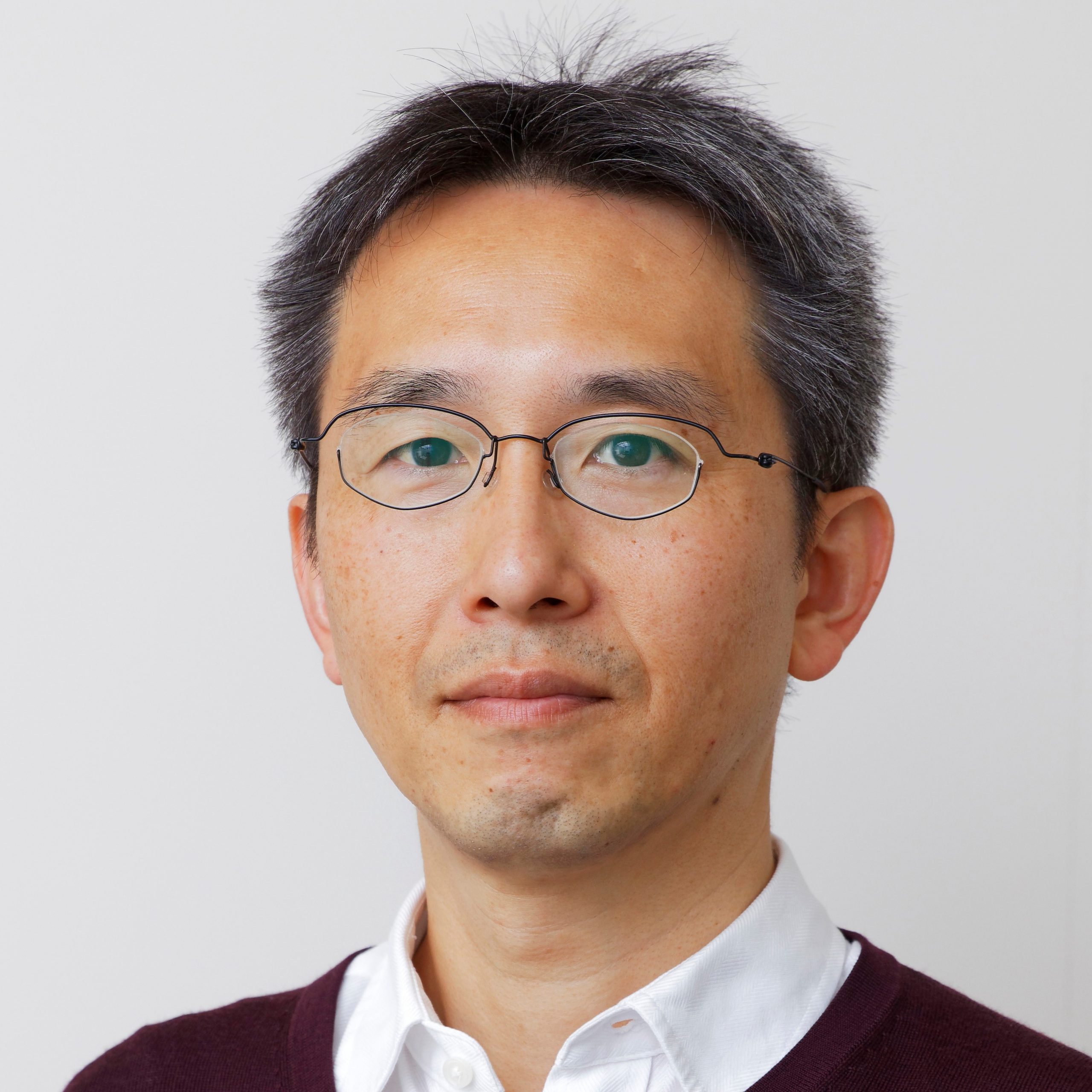 鷲山幸信准教授のポートレート。眼鏡をかけた中年男性が微笑んでいる。