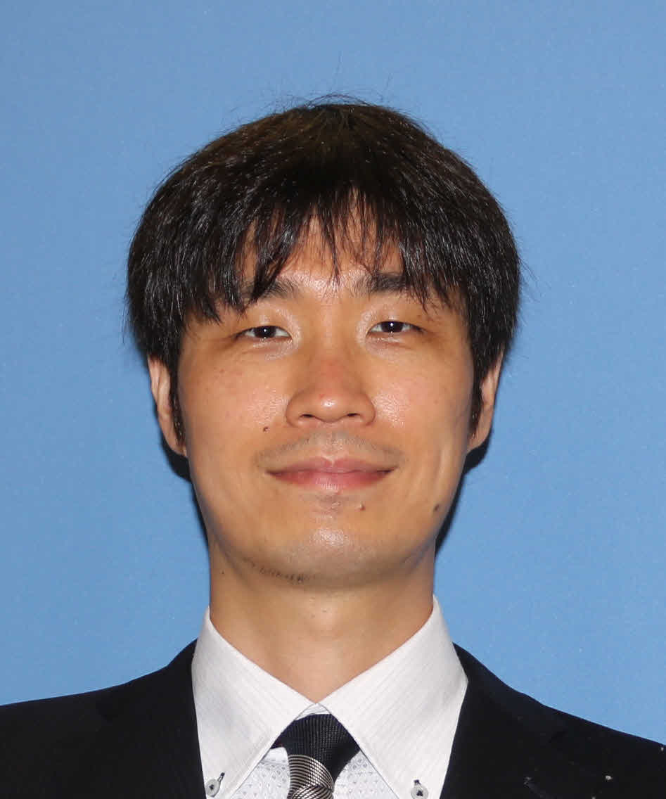 医療関係の講師である安田一行氏のポートレート写真。青い背景の前で微笑んでいる。
