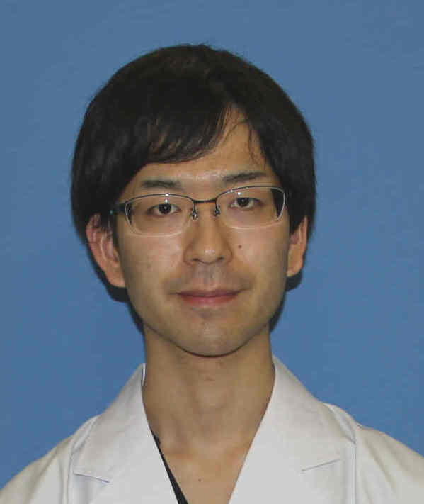成人発症スティル病に関する研究を行う松本聖生助教のポートレート。白衣を着用し、背景は青色。