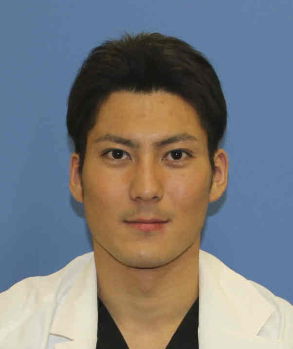 医療用白衣を着た男性のポートレート写真。背景は青色。